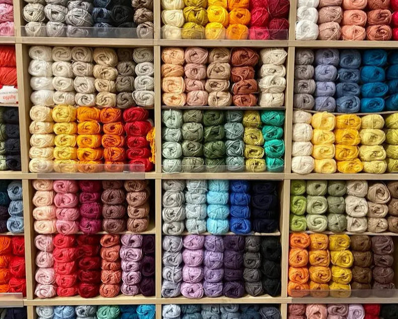 Shelves filled with colorful yarn rolls in a grid pattern